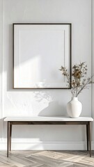 Fototapeta premium Minimalist interior design with a blank picture frame and a vase of flowers on a console table.