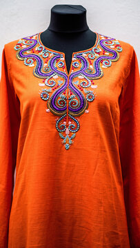 Vibrant orange tunic with colorful embroidered neckline