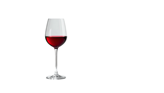 Red wine fills a clear wine glass on a stark black background