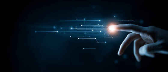 Close up of a finger touching a glowing point in a network of digital light lines
