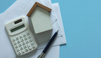 close up top view group of home model ,pen, calculator and invoice letter on blue color background with space for money management ,home loan and personal financial concept