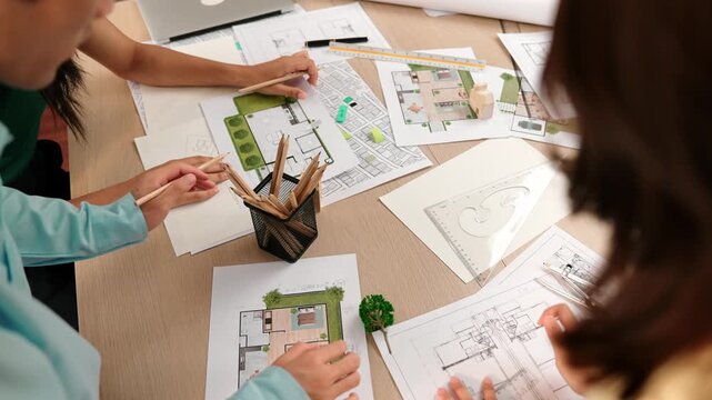 A video of architect team discuss with engineer hand writing a detail on blueprint during meeting to brainstorm construction idea at modern architectural office. Focus on hand. Closeup. Delineation.