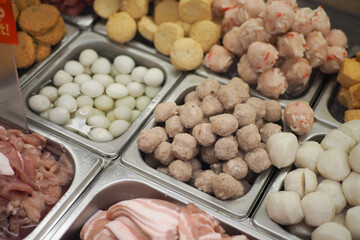 Variety of fresh meats and fish balls displayed in a market