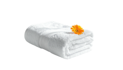 Folded white towel topped with vibrant orange flower bloom