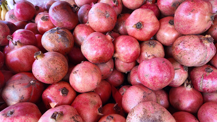 Fresh pomegranates stacked in a market at midday