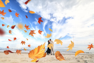 the romance of autumn, a couple in love against the background of autumn leaves and the sky on the seashore