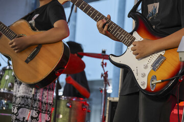 Passionate musician playing electric guitar in live band performance. music concert on stage with guitarist creating an energetic rock sound with an acoustic player