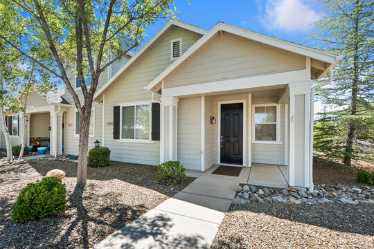 A quaint house with a black door and a direct walkway