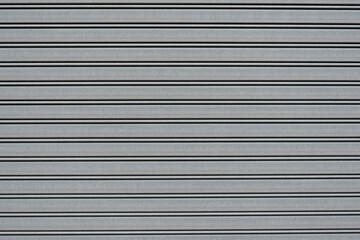 風化と経年劣化によるテクスチャ：白い壁に規則的な横線のクローズアップ