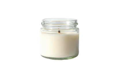 Small glass jar candle with white wax against a black background