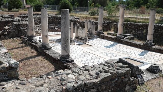Scenic summer view of archaeological site of Heraclea Lyncestis near Bitola, North Macedonia, overlooking ruins of ancient layered stone walls, marble columns, and surrounding greenery