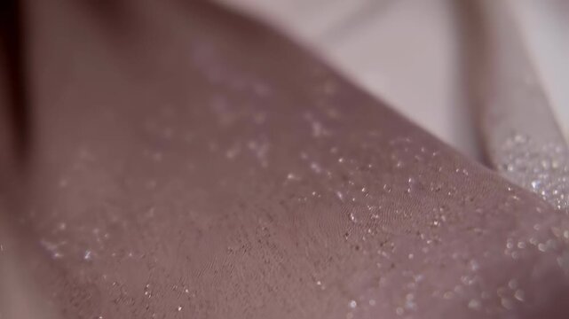 Close up footage of shimmering surface textures in soft lighting