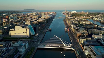 Aerial dolly view from Samuel Beckett bridge or know as Harp Bridge on Liffey River, the convention centre and the port of Dublin in the background.