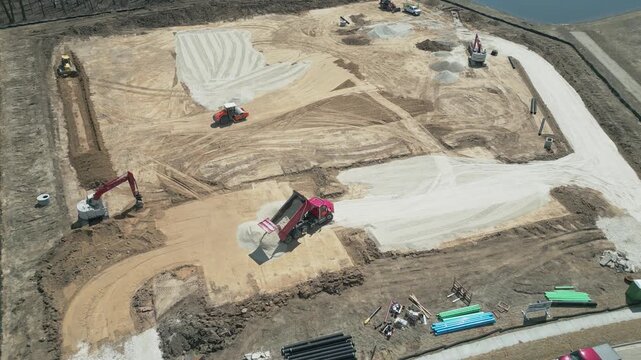 Aerial birds eye view of construction trucks laying out the foundational groundwork for a new construction site in the (up and coming area) of Ozaukee County, Milwaukee, Wisconsin.