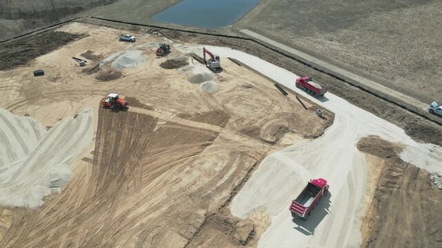 Top Down Aerial Construction site: dump truck, excavator, bulldozer, and forklift working on a new development project in Ozaukee County, Milwaukee, Wisconsin.