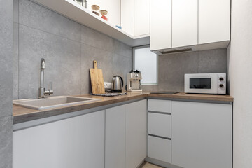 Fototapeta premium Modern Compact Kitchen with Wooden Countertop and Appliances