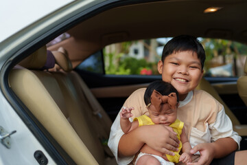 A group of brothers is holding their little sister at the door of the car.