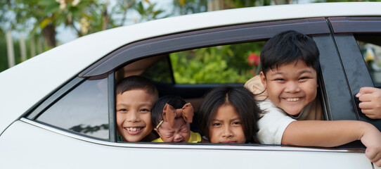 A group of brothers is holding their little sister at the door of the car.