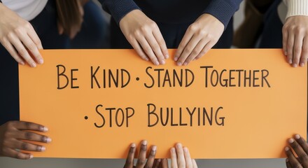 Diverse group of people holding orange sign with message be kind stand together stop bullying promoting unity empathy and anti bullying awareness