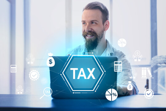 Man smiling while working on laptop with tax graphics and icons in a modern office setting