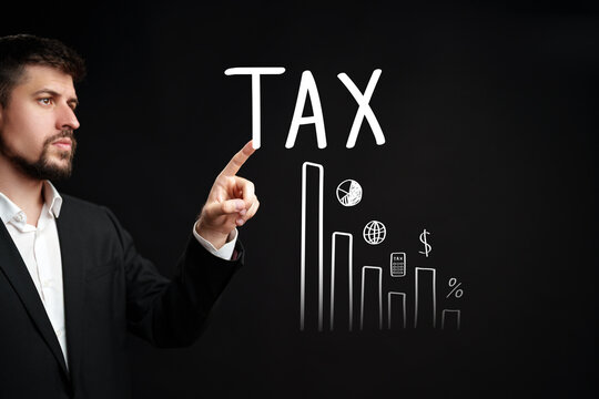 Businessman pointing at tax graphs on a blackboard during a financial meeting