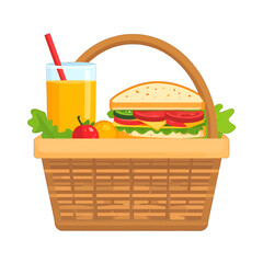 Wicker picnic basket filled with a tall sandwich juice and fresh fruit on a sunny day