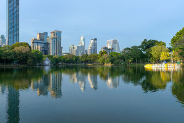 Inside green public center park on Bangkok, Thailand with canals and boats on docking for rent to relax on holidays or after work, surrounded modern buildings © CHIRADECH