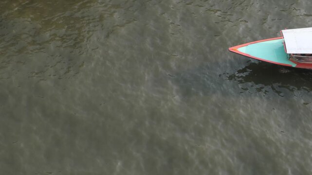 Aerial view of a passenger boat sailing on the Saen Saep Canal to pick up and drop off passengers at piers in Bangkok.Traveling by ferry is another option that can avoid traffic congestion on the road