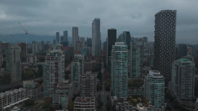 Wide rising aerial shot of the downtown skyline on a rainy afternoon in Vancouver, British Columbia, Canada. 4K