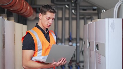 Focused technician plumber diligently monitors industrial systems. Skilled worker ensures efficient equipment operation. Professional approach with calm confidence demonstrated.