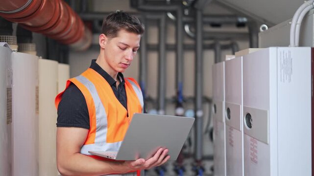 Focused technician plumber diligently monitors industrial systems. Skilled worker ensures efficient equipment operation. Professional approach with calm confidence demonstrated.