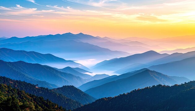 A vast mountain landscape unfolds in layers, with the closest peaks covered in dark green trees and distant ranges fading into a soft blue haze.