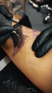 Tattoo Artist Creating Dotwork Design on Client's Leg