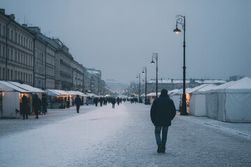 snowy evening scene at bustling christmas market illuminated by ultrabright lights and ar indicators