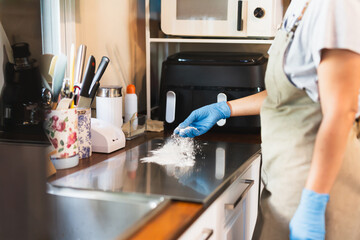 Baker women hand sprinkle the flour on baking tray.