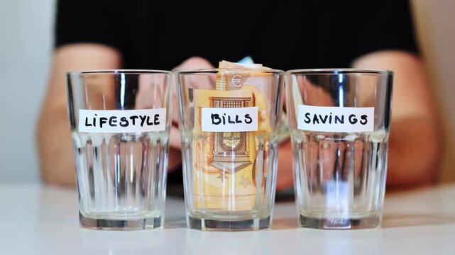 Man prioritizes saving - placing last cash into savings jar, empty lifestyle jar