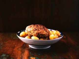 Fried meatballs with potatoes on a rustic background. Selective and soft focus.	