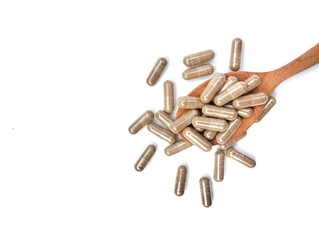 Herbal capsules on wooden spoon isolated on white background. Organic supplements for health, Flat lay 