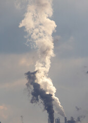 A large cloud of smoke is rising from a factory