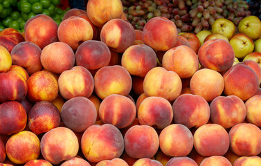 A pile of peaches are stacked on top of each other