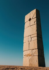 A colossal, abstract stone monument stands tall against a vast sky, representing enduring strength and timeless solitude and mystery ,stone ,towering ,contemporary