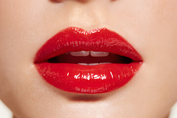 Fototapeta premium A close-up, of a woman’s lips wearing bright red lipstick, perfectly smooth and glossy