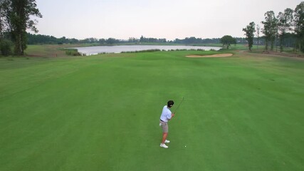 Drone view of young pro golfers swings the club on scenic golf course. 