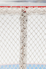 Lacing the net on the back post of a hockey goal - hockey equipment