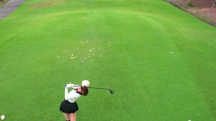 Drone view of professional female golfer playing on scenic golf course. - Powered by Adobe