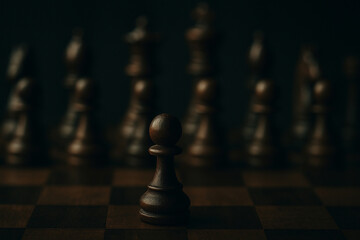 A solitary black pawn stands forward on a chessboard, facing a blurred, looming line of darker pieces, symbolizing a challenging game ahead