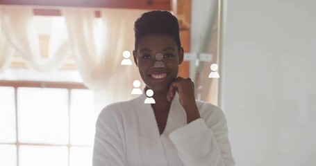Standing woman wearing white bathrobe at vanity near window, showing overlaid user icons