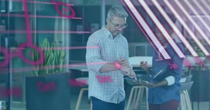 Reviewing team in checked and denim shirts examining tablet at office, with pink glass wall notes