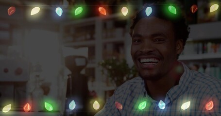 Smiling man wearing checkered shirt serving espresso at cafe with colorful lights, copy space