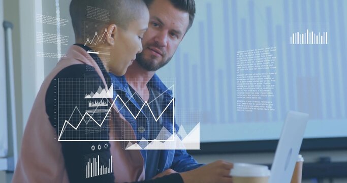 Leaning colleagues in denim and pink blazer examining laptop at meeting, with coffee cup and graphs